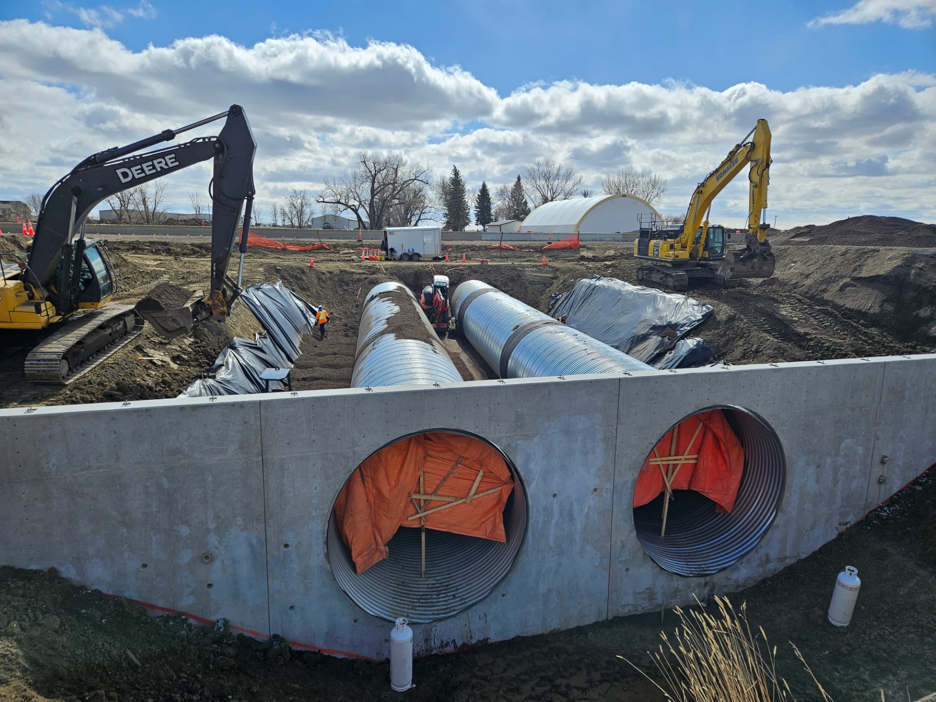 Culvert installation with concrete headwall and excavators on site